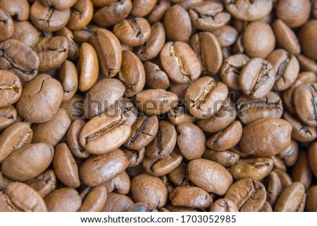 Roasted brown coffee beans close up background