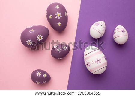 Easter greeting card with colorful easter eggs on pink and purple backgrounds. Top view flat lay with space for your greetings.