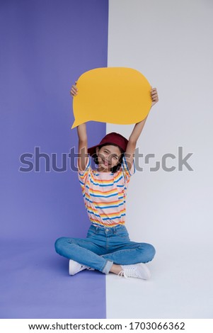 Happy asian young girl hold yellow bord with pastel background.