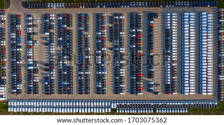 Aerial view of a car distribution centre, new cars parked in rows on a lot ready for sale.