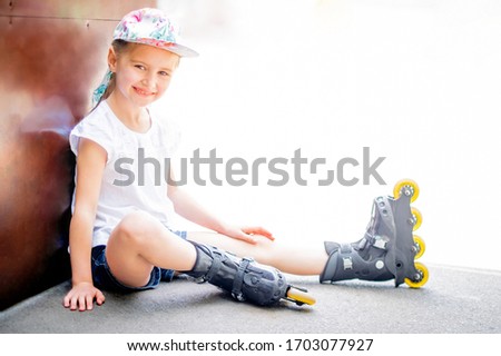 Cute smiling little girl on roller skates in park