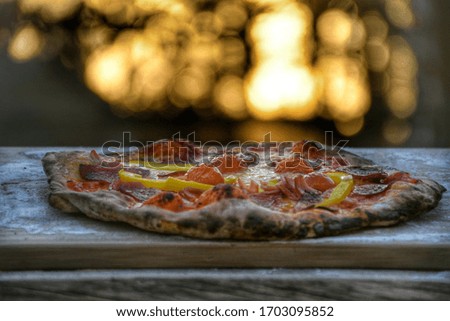 handmade pizza on a cutting board with a sunset in the background