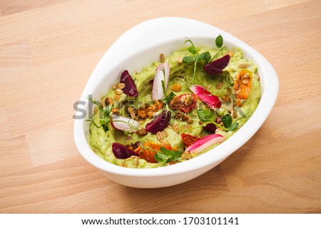 Organic plant based hummus with granola tomato, fresh thymes and rose leaf toppings. Perfect for vegan gluten free. Food photography. Royalty-Free Stock Photo #1703101141