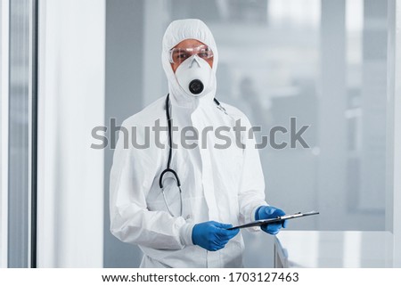 Male doctor scientist in lab coat, defensive eyewear and mask.