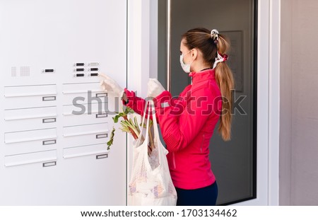 Young woman helping neighbors by shopping groceries for people in covid-19 quarantine Royalty-Free Stock Photo #1703134462