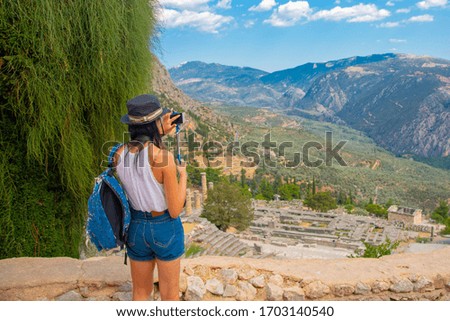 a girl takes photos of a beautiful view on her smartphone