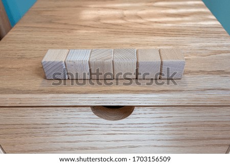line of wooden blocks, building cubes for mock up template on a wooden bureau, blue room, top view