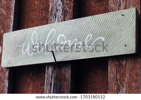 Welcome rustic wood sign on the old wood background