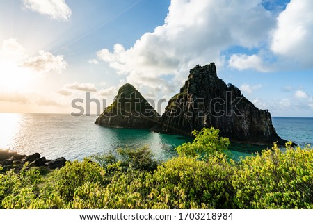 Beautiful Sunset at Cacimba do Padre beach with the view of Dois Irmaos Hill and turquoise clear water, at Fernando de Noronha, Unesco World Heritage site, Pernambuco, Brazil, July 2019