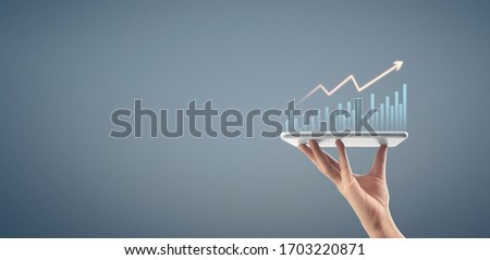 Businessman plan graph growth and increase of chart positive indicators in his business,tablet in hand Royalty-Free Stock Photo #1703220871
