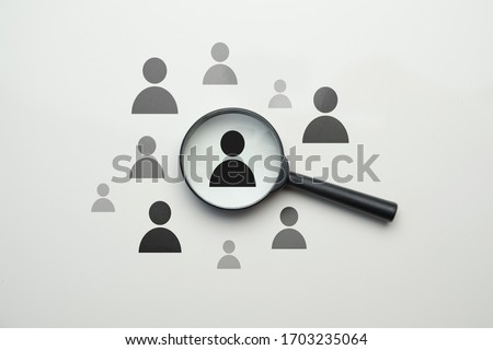 Employee search HR concept - magnifier with abstract employee on a white background. Close up. Royalty-Free Stock Photo #1703235064