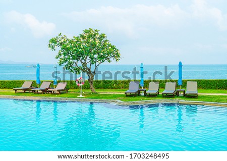 chair pool and umbrella around swimming pool with ocean sea background