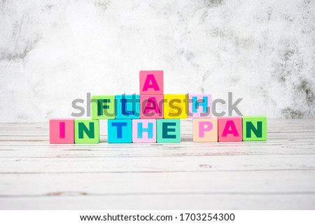 "a flash in the pan"-the words on wooden cubes.  A background image of english words on colorful building blocks.