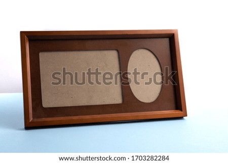 an empty wooden photo frame and mat on a blue table