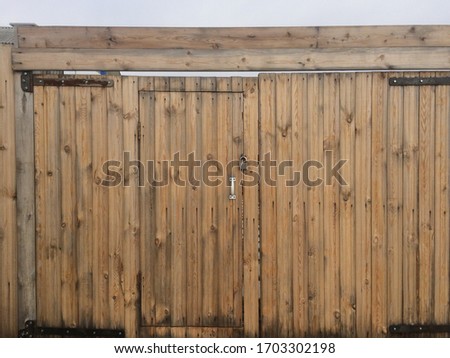 wooden textured light fence with a gate closed by a bolt