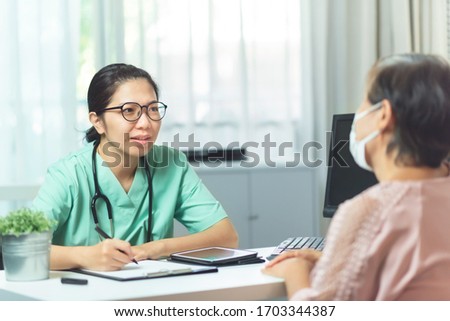 Beautiful Asian Woman Doctor or nurse wear glasses talking and giving advice to Elderly woman patient in medical room at the hospital. Disease, Ill, Flu, Sick of people. Covid-19,  BeH3althy.