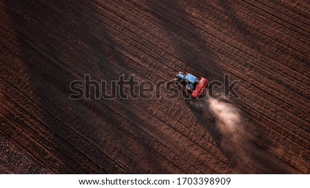aerial view of tractor , combine cultivating field. drone shot. picture with space for text. Farmland from above