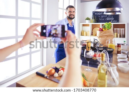 Portrait of handsome man filming cooking show or blog