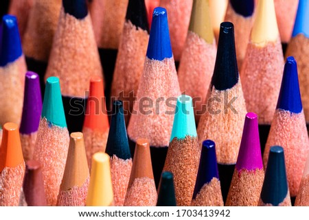 A high detail macro image of sharpened colored pencil ends, staggered in height and depth.  Deep DOF and vivid colors.
