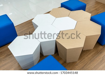Hexagon shape chairs on wooden floor in rest area. Interior design detail.