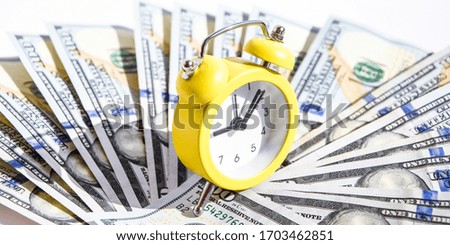business financial ideas concept with banknotes stack and alarm clock background with free copy space for creativity text. time is money. time is worth the money. time is more valuable than money, 100