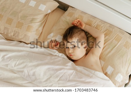 Sleepy Boy in Bed on Pillow and Covered by Blanket Flat Lay. Dreaming Relaxation Serious Preschooler Child after Sleep. Morning of Tired and Tranquil Caucasian Kid. Top View Photography
