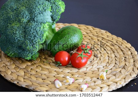 Vegetables broccoli, avocado, tomato on brown background
