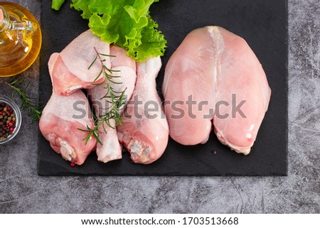Raw chicken meat, chicken legs and spices on dark background. Royalty-Free Stock Photo #1703513668