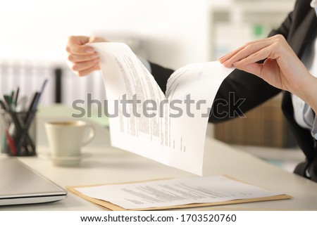 Close up of business woman hands breaking contract document sitting on a desk at the office Royalty-Free Stock Photo #1703520760