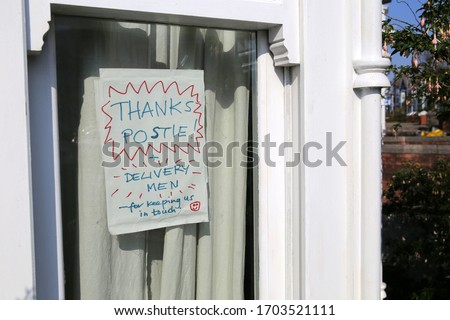 Homemade sign in a house window thanking postmen and deliverymen during the coronavirus lockdown