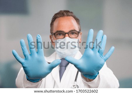 doctor with medical face mask and medical gloves shpws stop