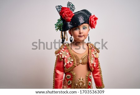 Young little caucasian kid girl wearing  bullfighter traditional folkore spanish suit as carnival costume standing over isolated background