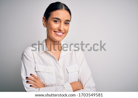 Young beautiful brunette woman wearing casual shirt over isolated white background happy face smiling with crossed arms looking at the camera. Positive person.