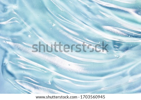 Blue gel texture. Hand sanitizer, alcohol gel background. Cosmetic clear liquid cream smudge. Transparent skin care product sample closeup Royalty-Free Stock Photo #1703560945