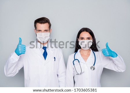 Photo of professional experienced doc guy lady virology clinic raise thumbs up agree infection prevention control wear protective masks latex gloves lab coats isolated grey color background