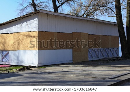 Abandoned wooden open-air cafe with boarded up plywood windows and door in the beach in Hydropark. Dnipro River in Kyiv. Isolation period in the city. Corona virus (Covid-19) prevention. Ukraine.