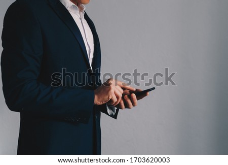 Close-up image of businessman hands using smartphone. Copy space

