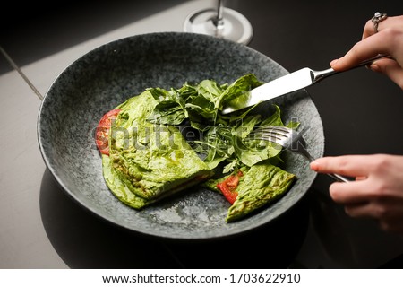 a vegetarian dish is cut with a knife on a plate