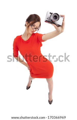 Girl in a red dress with shiny camera on a white background
