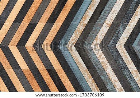 Multicolored vintage wooden wall with herringbone pattern. Weathered wooden planks texture for background.