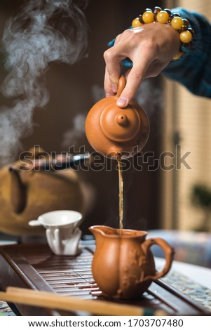 Tea ceremony. Tea is pouring from the kettle.