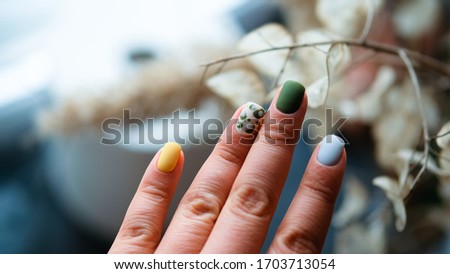 Luxury short matt manicure on a dark wooden background. Top view