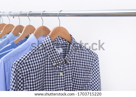 row of colorful row shirts hanging on hangers on a white background