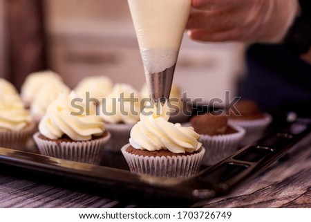 Chocolate cupcakes with a swirl of cream close-up. Selective focus. Royalty-Free Stock Photo #1703726749