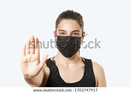 Young woman wearing protective mask on face. Showing stop sign. Confident girl, female doctor in medical mask and protective gloves. Coronavirus COVID-19 protection. woman in protective mask.