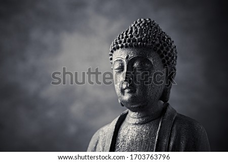 Meditating Buddha Statue on dark background. Copy space. 