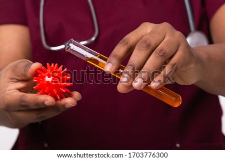 Covid-19, Vaccine development , outbreak and medicine concept - Doctor in medical protective mask holding a model of coronavirus and test tube close-up.