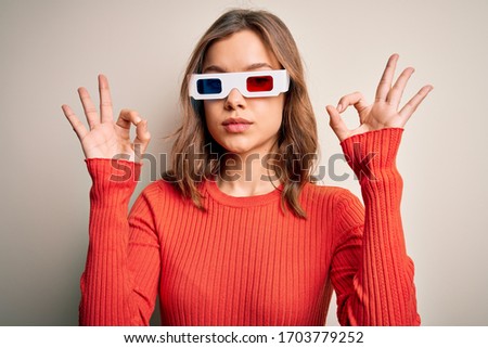 Young blonde girl wearing 3d cinema glasses over isolated background relax and smiling with eyes closed doing meditation gesture with fingers. Yoga concept.