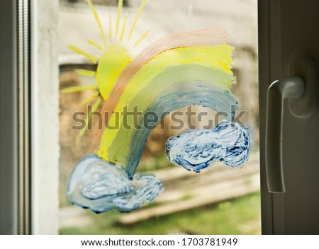 Rainbow flashmob on a window pane closeup. A rainbow on glass during quarantine due to coronavirus as a symbol of hope for the future. Close-up of a child's drawing of a rainbow on a window pane durin