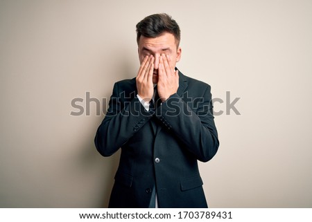 Young handsome business man wearing elegant suit and tie over isolated background rubbing eyes for fatigue and headache, sleepy and tired expression. Vision problem
